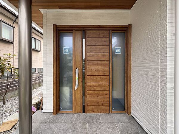 玄関ドアは木目がアクセントに。