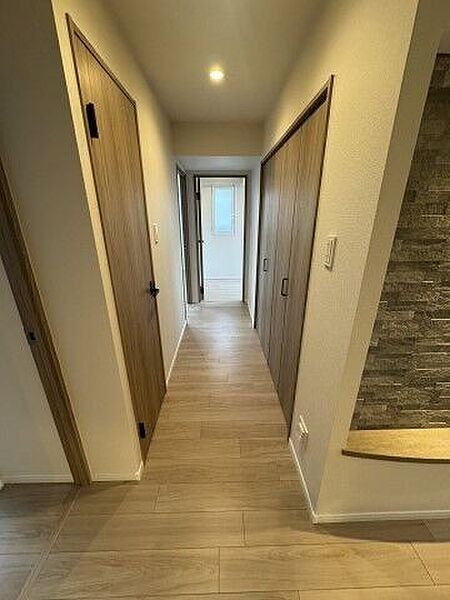 シックな石貼り調のアクセント壁と、足元をやさしく照らす間接照明が、住まいの第一印象を美しく格上げします