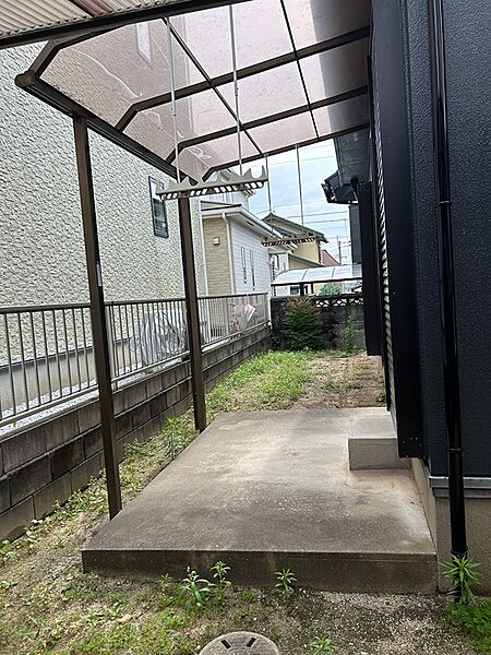 屋根付きのスペースは、雨の日も洗濯物を干せる便利な場所。庭には緑が広がり、ガーデニングなども楽しめます。