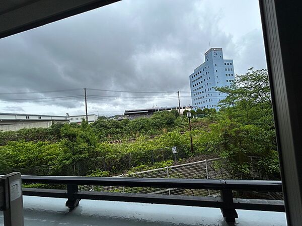 窓の外に広がる、多様な景色。鮮やかな緑と個性的な建物が、都市の躍動感を感じさせます。