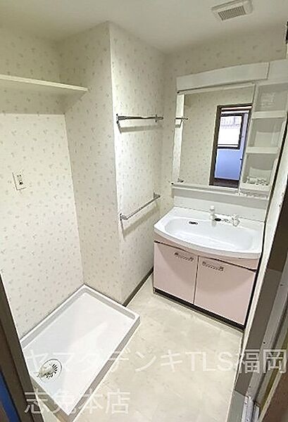 収納棚付きの洗面台は、身支度用品の整理に便利です。ピンクの扉がアクセントとなり、空間を明るく演出します。