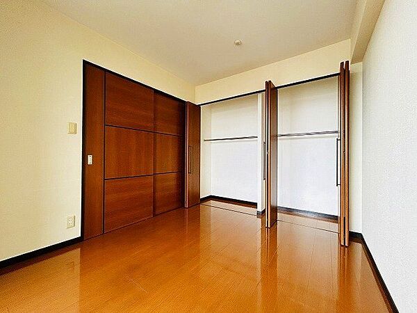 【洋室約9.5帖収納】居室には壁一面に収納が備え付けられています。衣類や荷物をすっきりと整理でき、空間を広々と活用できます。