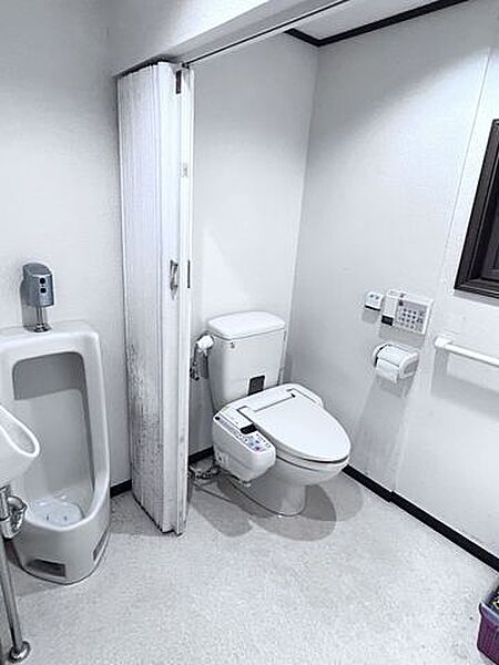 【トイレ】洋式便器と小便器があり、壁の手すりで立ち座りも安心してできる水回りです。