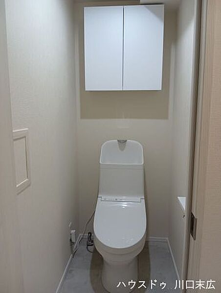 清潔感のある温水洗浄便座を採用。上部にはトイレットペーパーなどのストックに重宝する吊り戸棚を備えています。