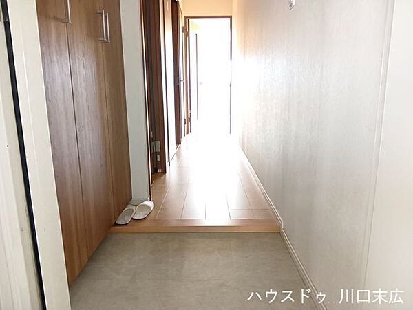 居室へと続く、フラットな造りの廊下です。木目調の建具が空間に温もりを与え、居住空間への期待感を高める上品な仕上がりとなっています。