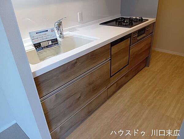落ち着いた木目調パネルが空間に調和するシステムキッチンです。使い勝手の良いワークトップと機能的なシンクを備え、毎日の料理を快適にサポートします。