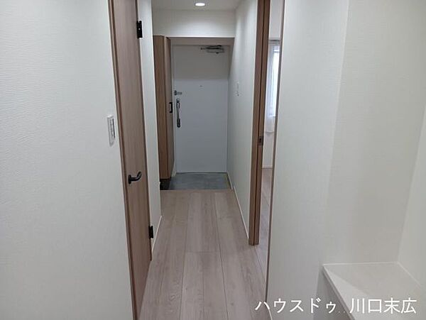 フローリング仕上げの落ち着いたプライベート空間へのアプローチ。各居室やサニタリースペースを機能的に繋ぐ洗練された動線設計です。