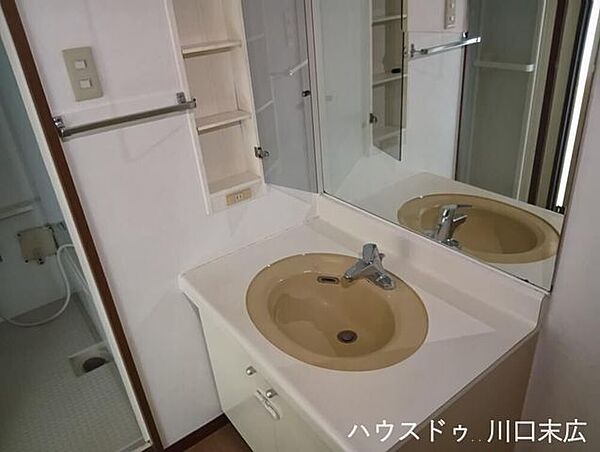 収納力のある棚と大きな鏡を備えた洗面台。洗面ボウル周りのスペースも広く、身支度や手洗いがスムーズに行えます。