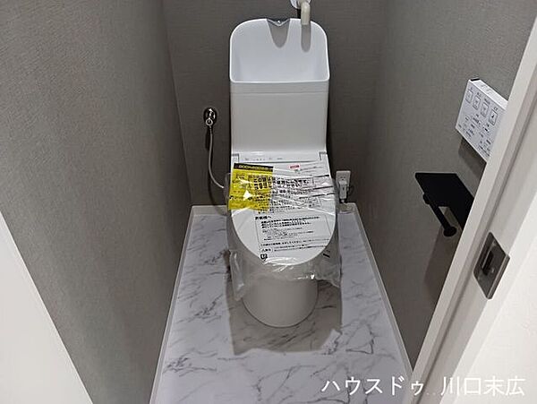 手洗い機能を備えた温水洗浄便座付きのトイレ空間。凹凸の少ないプレーンなフォルムで、日々の拭き掃除などもスムーズに行えます。