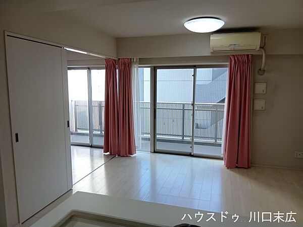 フローリングが続く居住空間。バルコニーへ続く掃き出し窓を備え、穏やかな家族の時間を過ごせる設計です