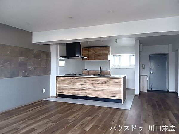 洗練されたデザインのアクセントクロスが印象的な居住空間。フローリングの美しい木目が落ち着きを与え、ご家族がゆったりとくつろげる上質なライフスタイルを演出します。