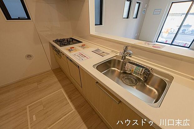 リビングの家族と会話が弾む対面式。浄水器一体型水栓を配したシンクは、手元を隠す腰壁仕様により生活感を抑えたスッキリした印象を維持。機能的なワークスペースを実現。