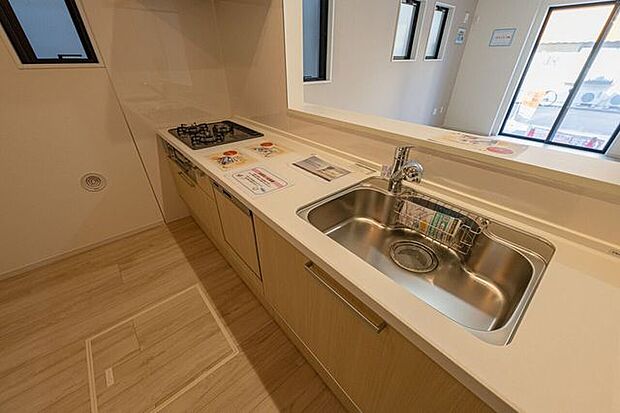 リビングの家族と会話が弾む対面式。浄水器一体型水栓を配したシンクは、手元を隠す腰壁仕様により生活感を抑えたスッキリした印象を維持。機能的なワークスペースを実現。