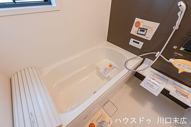 心ゆくまでリラックスできる、ベンチ付き浴槽を採用したバスルーム。木目調の壁面パネルが上質なひとときを演出し、一日の疲れを穏やかに解きほぐす癒しの空間です。