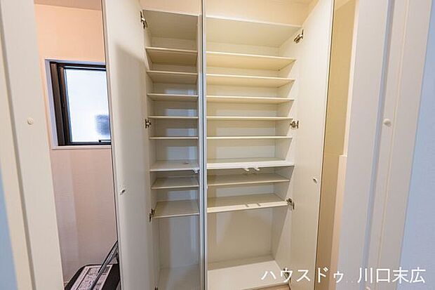 家族の靴を効率よく収める、可動棚仕様のシューズボックス。扉の大型ミラーが外出前の身だしなみをスマートに整え、玄関空間をより奥行きのある印象に仕立てます。