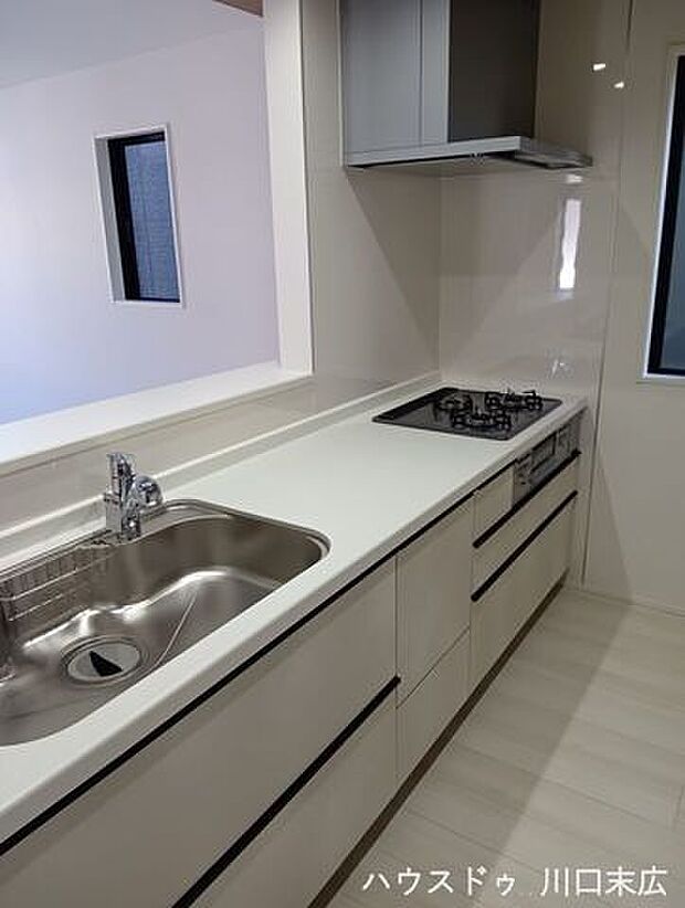 リビングを見渡せる対面式キッチンは、家族との繋がりを感じられる特等席です。 ホワイトで統一された清潔感のあるシステムキッチンに、ブラックのライン取っ手が映える都会的なデザイン。