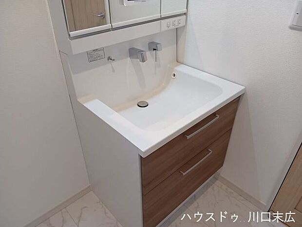 白を基調とした清潔感のある洗面化粧台。鏡裏や足元の収納スペースにより、洗面周りの小物をすっきりと整理整頓できます。