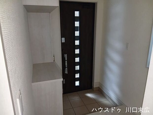 縦のスリットから光を取り込む玄関ドアと、トールタイプのシューズボックス。棚板の高さを調整でき、ブーツや長靴も効率よく収納可能です。