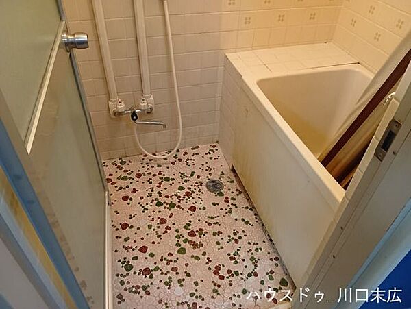 レトロな風合いのタイル床が特徴的なバスルーム。一日の疲れを癒やす、シンプルで使い勝手の良い入浴空間です。