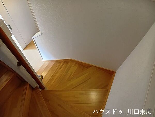 木の温もりが感じられる階段部分。手すりが設置されており、ご家族皆様の安全な昇降をサポートする造りです。