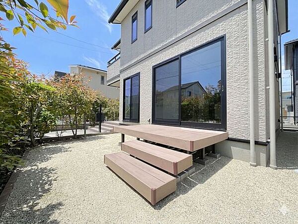 お庭付きの敷地でウッドデッキ付き。樹脂製デッキで天然木に比べて耐久性に優れ、雨や日光による劣化が少ないのが特徴です。※AIにて雑草を削除しております。