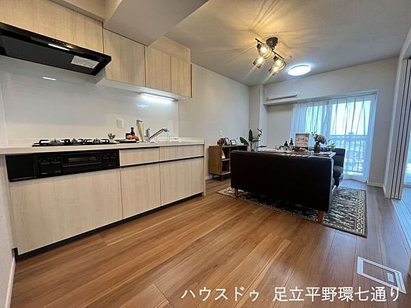 木目調のキッチンが映える明るいLDK。家族が自然と集まる心地よい空間です。