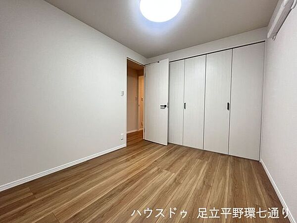 壁一面に収納を備えた洋室。衣類や荷物をまとめて収納し、室内を広く使えます。