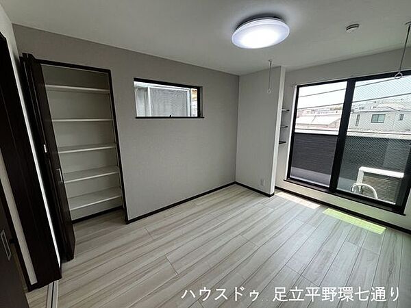大きな窓から陽光が差し込む明るい洋室。バルコニーに面しており、開放感のある快適な住空間です。