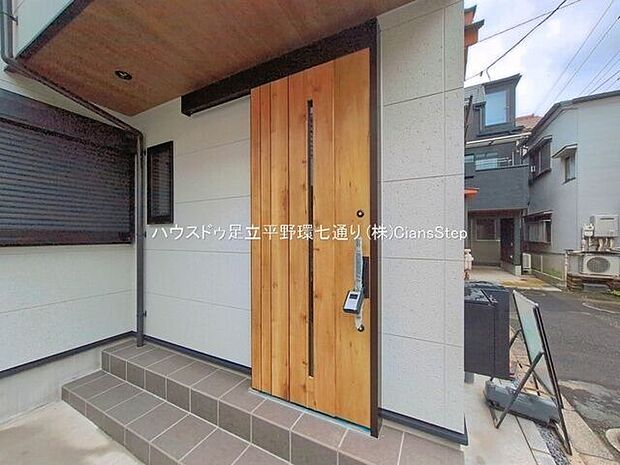 木目調の玄関ドアが住まいの印象を明るく演出。屋根付きの玄関ポーチで、雨の日の出入りにも配慮されています。