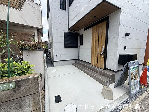 木目調の玄関ドアと白い外壁が調和したスタイリッシュな外観。すっきりとした印象の住まいです。