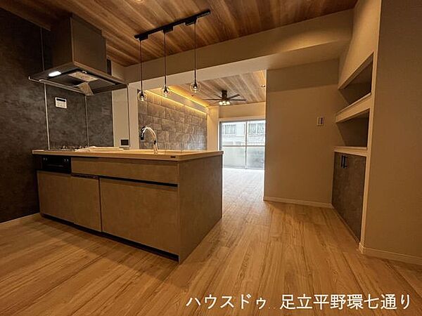 木目天井と間接照明が映える、デザイン性の高い対面キッチン。上質感のあるLDK空間を演出します。