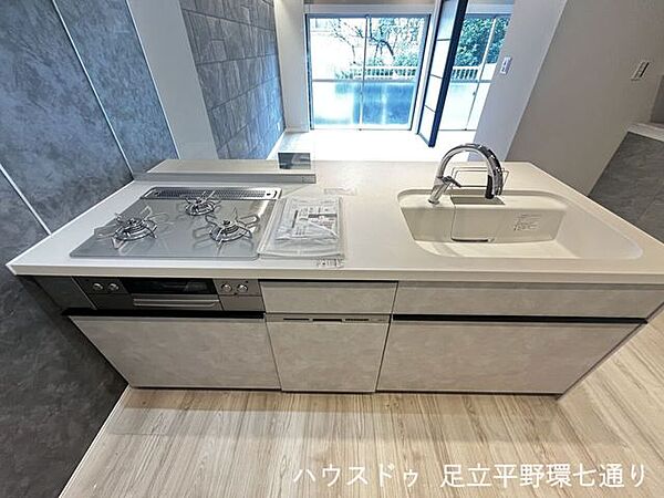 3口コンロと広々シンクを備えた使いやすいシステムキッチン。料理も後片付けもスムーズです。