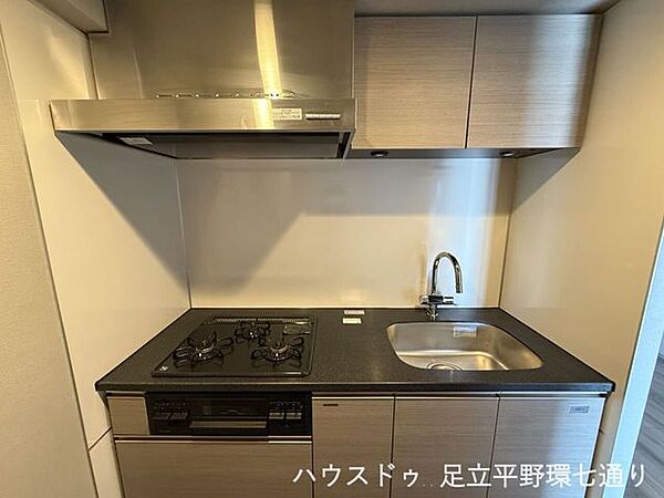3口ガスコンロと収納を備えたシステムキッチン。調理スペースも確保され、家事がはかどります。