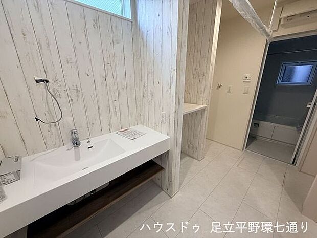 ワイドな洗面台とオープン収納を備えた洗面スペース。身支度から収納まで使いやすい設計です。