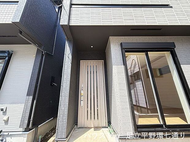 玄関まわりは屋根付きで、雨の日の出入りもスムーズ。木目調の玄関ドアが外観のアクセントです。