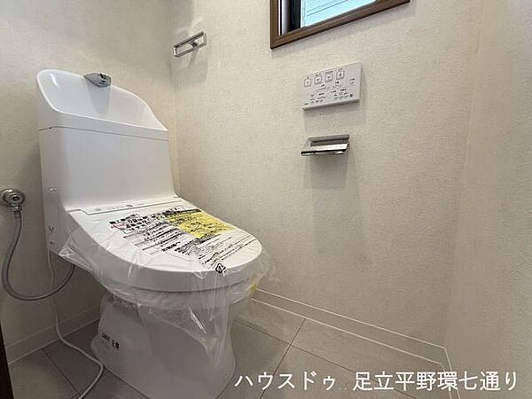温水洗浄便座を備えた清潔感のあるトイレ。小窓付きで自然換気がしやすく、快適に使用できます。