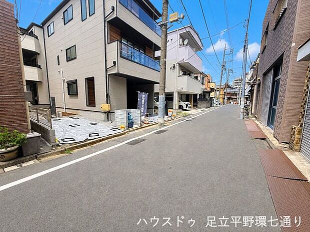 前面道路はすっきりとした印象。周辺は住宅や店舗が並ぶ、暮らしやすい街並みです。