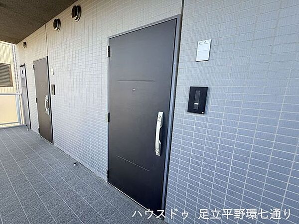 落ち着いた色合いの玄関ドアとタイル貼りの共用廊下が、上品な印象を演出します。