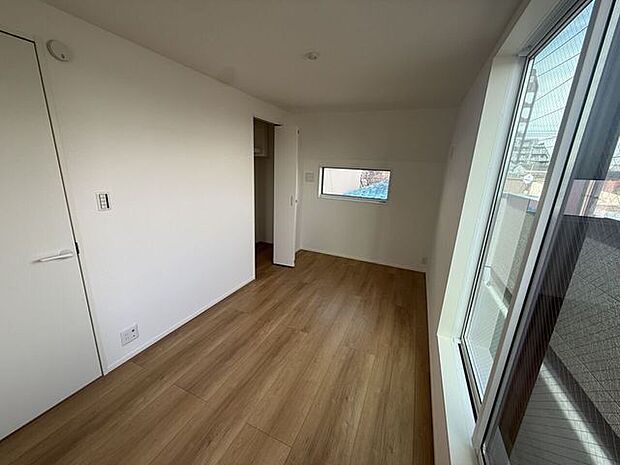 大きな窓から光が差し込む明るい洋室