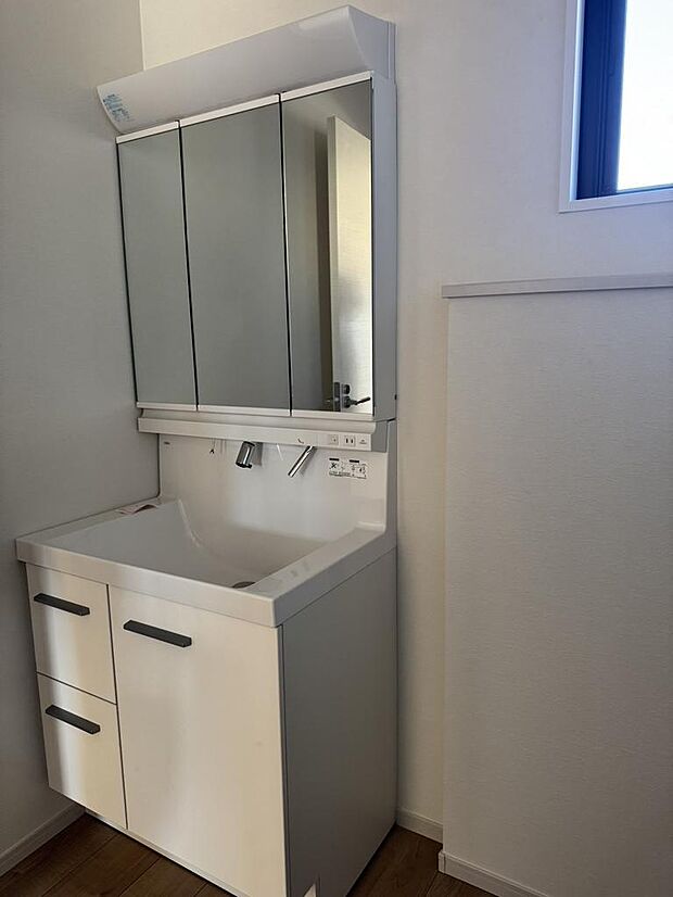 三面鏡付き洗面化粧台。収納スペースも確保。