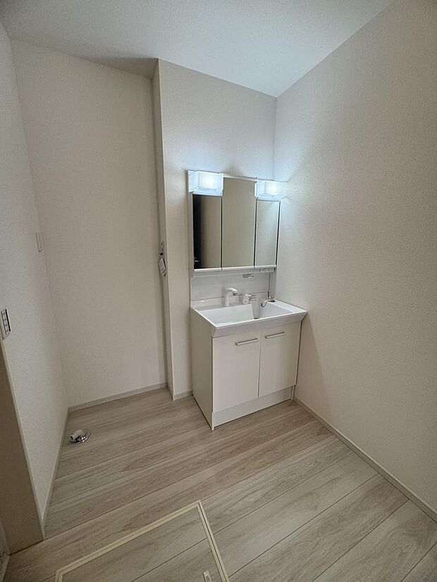 三面鏡付き洗面化粧台。収納豊富で朝の身支度も快適、子育て世帯にも便利です。