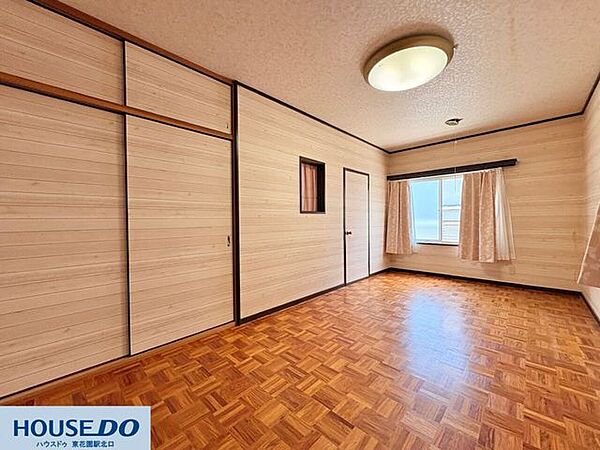 木の温もりを感じる壁紙とデザイン性の高い床が調和した室内です！窓からは優しい光が差し込み、日中の読書や作業も心地よく進みそう♪収納扉も壁と一体感のあるデザインで、お部屋を広く見せてくれます☆