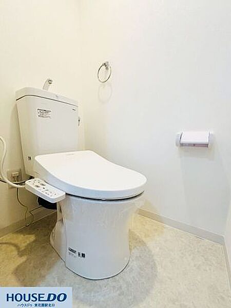 白を基調とした清潔感あふれる温水洗浄便座付きのトイレです。壁面にはペーパーホルダーやタオルリングがすっきりと配置されており、シンプルで使い勝手の良い空間となっています！