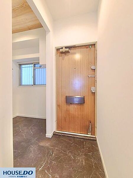 シックなダークトーンのフロアが印象的な玄関アプローチ！落ち着いた色合いのドアと相まって、住まいの入口を上質かつスタイリッシュに演出します♪