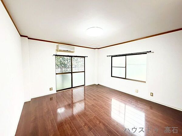 1階8畳洋室大きな掃き出し窓から明るい陽光が差し込み、お部屋にいながら外の緑を感じられる開放的な空間。明るく清潔感あふれる一室です。