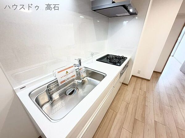 白を基調とした清潔感あふれるキッチン。コンパクトながらも使いやすく、毎日の料理がはかどります。