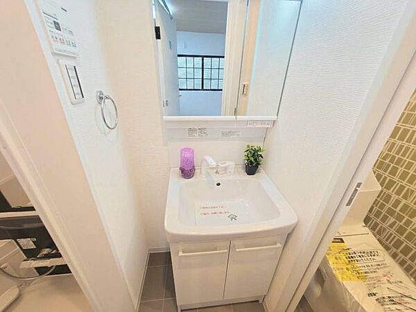 大きな一面鏡と手入れのしやすい洗面ボウルを備えた洗面化粧台。足元には収納スペースがあり、洗剤や日用品をすっきりしまえます。