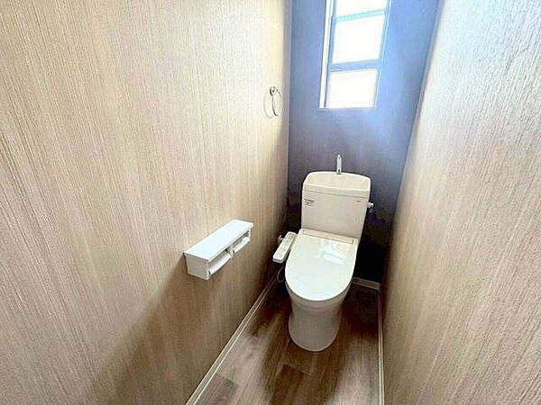 木目調の壁紙とシックなアクセントクロスが調和した、落ち着きのあるレストルーム。窓から届く光と温かみのある内装が心地よい個室空間を演出し、日々の暮らしの中でホッと一息つける安心感があります。