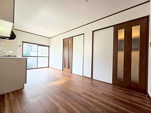 深みのあるブラウンの引き戸が、空間に落ち着きを与えています。廊下とを仕切る扉はすりガラス調になっており、閉めていても光が通る工夫が施されています。圧迫感が少なく、お部屋全体が明るく感じられる造りです。