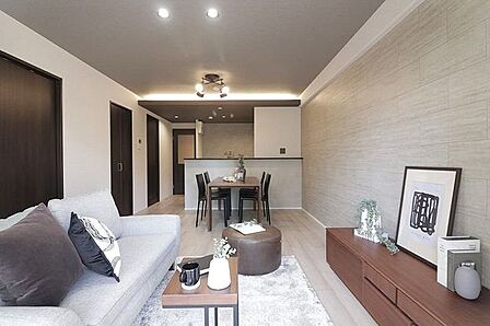 グレーのアクセントクロスと落ち着いた木目が調和するモダンな内装デザイン。奥行きを感じられるレイアウトで、ゆったりとした時間が流れます。